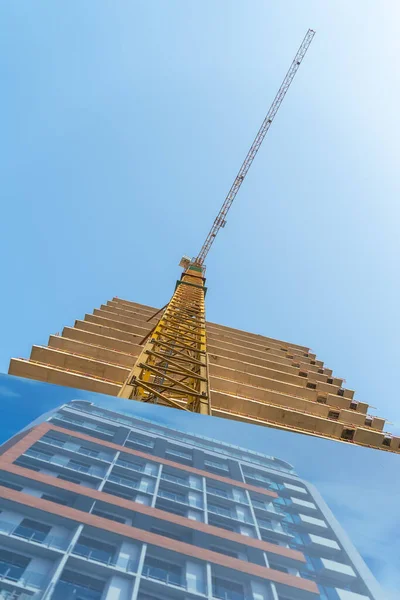 Крупный План Желтого Строительного Крана Части Строящегося Многоэтажного Здания Голубом — стоковое фото