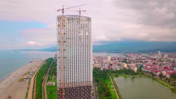 Воздушный полет на беспилотнике над строительной площадкой с высоким башенным краном — стоковое видео