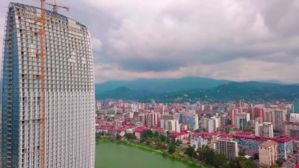 Воздушный полет на беспилотнике над строительной площадкой с высоким башенным краном — стоковое видео