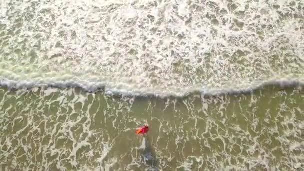 Tirant d'un drone, une femme entre dans la mer, et se réjouit. bonheur. — Video