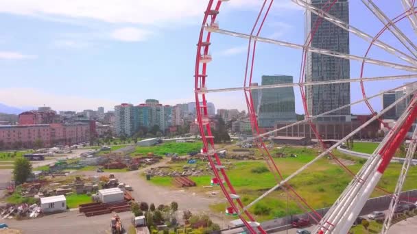 Fotografia aerea di un drone che vola intorno a una ruota panoramica sulla riva del mare — Video Stock