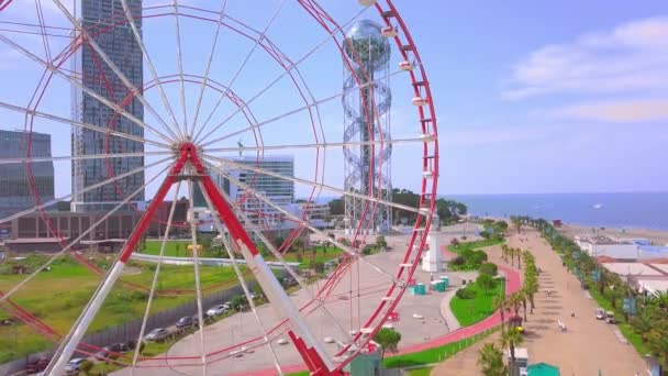 Flygfoto av en drönare som flyger runt ett pariserhjul på stranden — Stockvideo