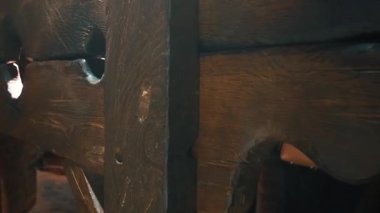 Karanlık ortaçağ işkence stokları eski, yıpranmış ahşap parıldayan bir ışık kaynağı tarafından aydınlatılmış, dramatik ve tarihi bir atmosfer yaratıyor bir zindanda veya eski bir kalede