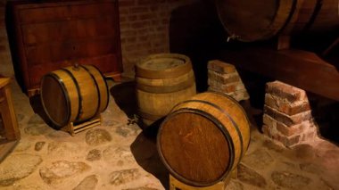 Klasik meşe fıçıları taş döşeme ve tuğla duvarları olan geleneksel bir yeraltı mahzeninde dinleniyor. Bu şarap yapımı ve alkol damıtma sürecinin önemli bir parçası.