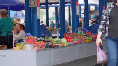 Minsk, Belarus - 13 Temmuz 2024: Alışverişçilerin sağlıklı ve organik bir yaşam tarzı için taze doğal ürünler, çilekler, domatesler ve salatalıklar aldıkları bir çiftçi pazarı