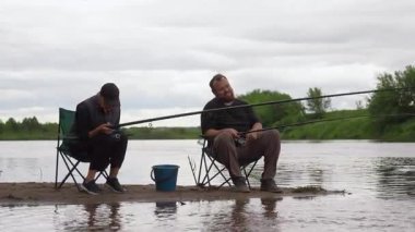Olgun bir adam ve kadın, sakin bir günün tadını çıkarıyorlar. Nehrin kumlu kıyısında birlikte balık tutuyorlar. Katlanan sandalyelerde oturup, huzurlu ve bulutlu bir günde avlanmayı sabırla bekliyorlar.