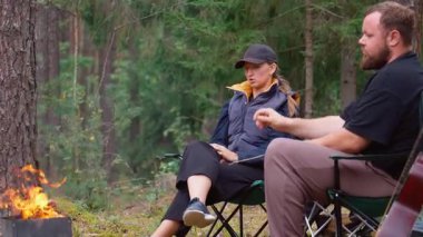 Genç bir adam ve kadın çam ormanında kamp sandalyelerinde oturuyorlar. İlişkilerindeki sorunlar hakkında ciddi ve düşünceli bir tartışmaya giriyorlar. Dışarıya çıktıklarında üzgün ve endişeli görünüyorlar.