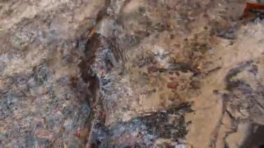 Renkli çakıl taşları ve kayaların üzerinden akan küçük bir dağ akıntısının kristal berrak suyu yüzeyde hafif dalgalanmalar yaratır. Doğanın saflığını gösteren barışçıl ve doğal bir arka plan.