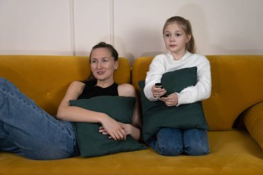 Evdeki sarı bir kanepede dinlenen rahibeler, televizyon seyredip yastık tutuyorlar, boş zamanlarında eğleniyorlar ve kardeşçe yakınlaşıyorlar.