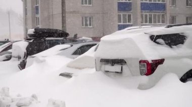karla kaplı araçlar konut otoparkında, derin sürüklenen araçlar apartman bloklarının yakınına gömülen araçlar, egzoz boruları gizli, buzlu yüzeyler, yoğun birikmiş sessiz fırtına atmosferi ve sessiz kentsel şehir