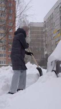 Beyaz kadın, park yerinde karlı arabayı temizliyor. Uzun bir cekete sarılmış, sürekli ritmik alışveriş yapıyor. Sabahları araba almak için yoğun çaba sarf ediyor.