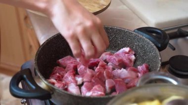 Şimdi et pişiriyorum. Fırında eşit derecede doğranmış et. Meşgul bir sobada et dilimleri aktif olarak kızartılıyor. Doğranmış et parçaları sıcak tava yüzeyinde cızırdıyor ve yayılıyor