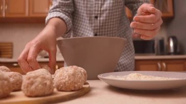 Köfteleri ya da kampetleri bir kase ve tabakta elle şekillendirin, daireleri ekmek kırıntılarıyla elle kaplayın ve onları tepsiye yerleştirin, yakın dokulara yerleştirin ve kızartma için düzgün bir şekilde ayırın.