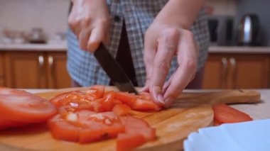 Gemide doğranmış domates hazırlıyorum. Kesik yüzeye yerleştirilmiş domates parçaları. Salata inşaatı sırasında dikkatlice dilimlenmiş domates parçaları doğrama tahtasının üzerine serilmiştir.