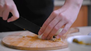 Yumurta doğrama sahnesi. Dilimlenmiş yumurtalarla kahvaltı hazırlıyorum. Elleri haşlanmış yumurtaları yemek için küçük parçalara ayırıyor. Kahvaltı için yumurta parçaları ile aşçılık sahnesi