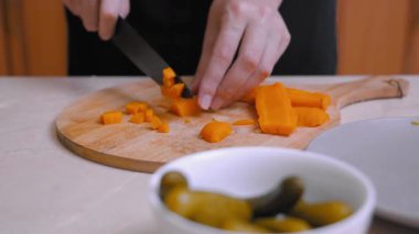 Havuç doğrama sahnesi. Mutfak tezgahında havuç ve turşuyla mutfak hazırlığı. Tahta tahtada taze havuç doğramak. Yanında da meze hazırlığı için turşu.