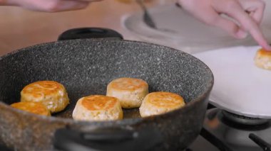 Çıtır çıtır bir spatulaya yakın çekim. Kahvaltıda şefin krep ya da cheesecake yaptığı bir sahne. Beyaz şef, sahnedeki altın krepleri ince bir tavayla ustalıkla kızarttı.