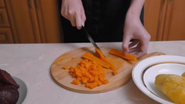 Havuç Kesme Sanatı. Üniformalı Havuç, Bulaşıkları Süslemek İçin Dikkatlice Kesiyor. Şef havuçları ustalıkla doğruyor. Tabakların yanında özenle ve özenle doğruyor.