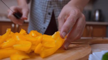 Lezzetli salsa için biber dilimliyorum. Keskin Bıçak Teknikleri Bulaşıklar için Canlı Biber Şekilleri Oluşturur. Mutfak Sunumu İçin İnce Şeritlere Sarı Biberleri Kesmeye Ayrıntılı Odaklanma