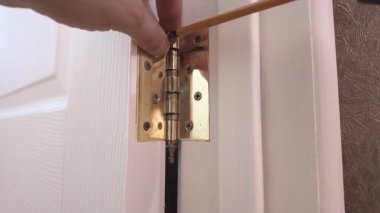 Kapı menteşesini tornavidayla sağlama alıyorum. Kapı menteşesini sıkılaştıran pirinç vidayı dikkatli kullan. Bireysel Güvenli Menteşe Hareketi Sağlama Almak İçin Beyaz Kapıya Vidalar