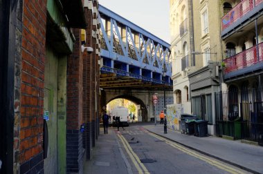 Londra, Birleşik Krallık - 15 Nisan 2019: Pazartesi sabahı Londra Köprüsü 'ne yakın cadde manzarası binaları, hareketsiz yayaları ve demiryolu köprüsünü gösteriyor