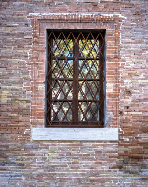 Okno Kratownicą Starej Murowanej Ścianie Murowanej Naprawioną Cegłą — Zdjęcie stockowe