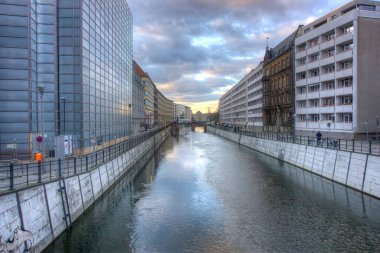 Berlin, Almanya - 26 Mart 2025: Hareket halindeki Spreekanal su yolu her iki taraftaki yaya, araç ve yüksek binaları bulanıklaştırdı