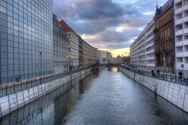 Berlin, Almanya - 26 Mart 2025: Hareket halindeki Spreekanal su yolu her iki taraftaki yaya, araç ve yüksek binaları bulanıklaştırdı