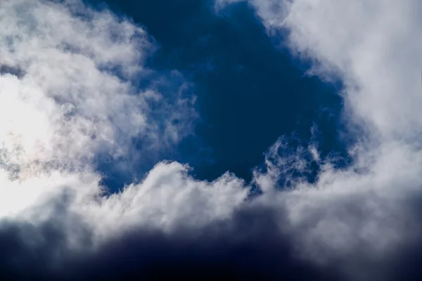 Солнце и облака на голубом небе — стоковое фото