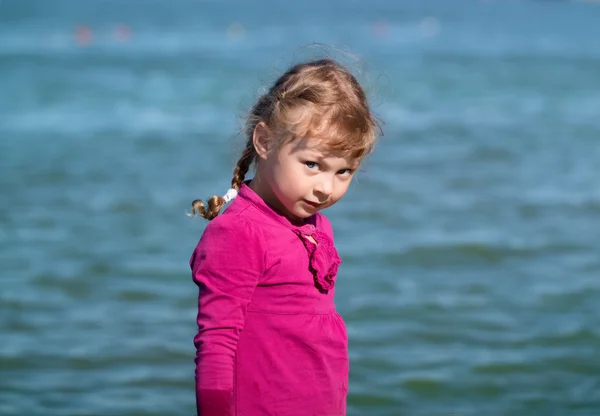 Kleines Mädchen mit blauen Augen, vor dem Hintergrund des Wassers Stockbild