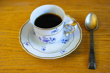 Porselen fincan kahve ve bir gümüş kaşık