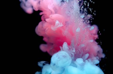 Suyun içinde çok renkli boyalar. Mürekkep suyun altında döner. Parlak mürekkep arka planında bir çarpışma bulutu. Soyut arkaplan