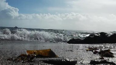 Deniz kayalık kıyı şeridine çarpar, engin kıyı dalgaları engebeli kayalık kıyı şeridi üzerinde güçlü bir şekilde dalgalanır.