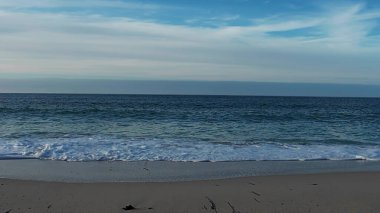 Deniz kayalık kıyı şeridine çarpar, engin kıyı dalgaları engebeli kayalık kıyı şeridi üzerinde güçlü bir şekilde dalgalanır.