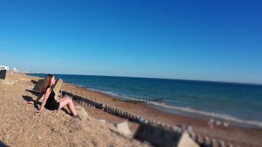 Bir kadın geniş ve sakin okyanus manzarasını gözlemler.