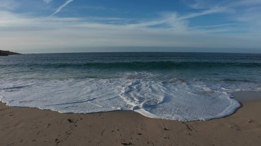 Deniz kayalık kıyı şeridine çarpar, engin kıyı dalgaları engebeli kayalık kıyı şeridi üzerinde güçlü bir şekilde dalgalanır.