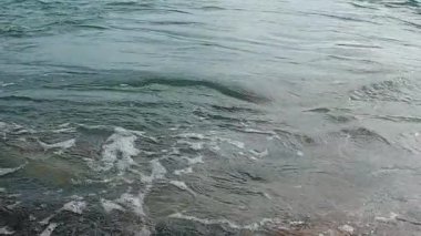 Güzel dalgalar enerji ve köpüklü sahil manzarası oluşturuyor. Yüksek kalite 4k görüntü