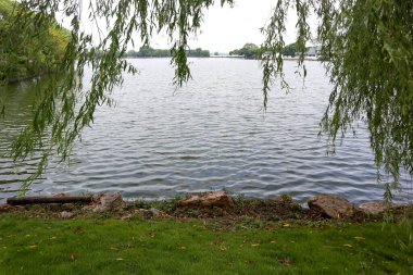Bu, Çin 'deki yemyeşil bir parkın güzel bir manzarası. Geniş çayırlar ve güzel göller insanların dinlenip oynayabileceği bir yer.