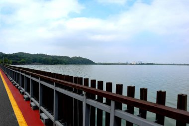 Bu Çin 'de güzel bir park manzarası. Gölün üzerinde güzel ahşap bir köprü var.