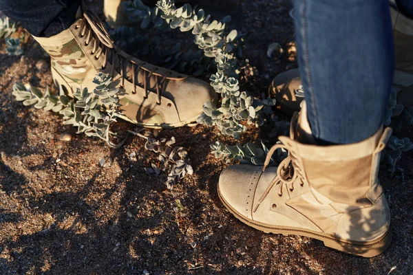 Man and woman in army beige boots spend outdoor activities in the wilderness. Caucasus, Russia