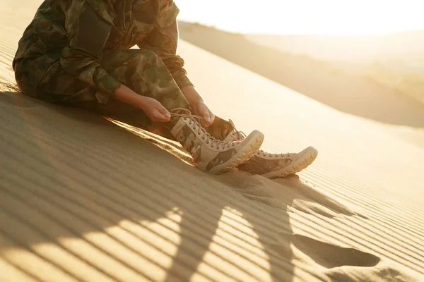 Tourist in army clothes and beige boots in the desert. Caucasus, Russia