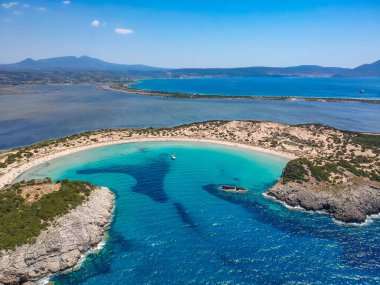 Voidokilia 'nın ünlü yarı dairesel kumlu plajı ve lagününün hava manzarası. Yunanistan 'ın Messenia kentinde kristal berrak turkuaz suyu bulunan Akdeniz' deki en ikonik plajlardan biridir.