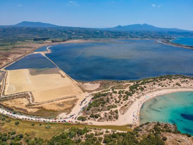 Voidokilia 'nın ünlü yarı dairesel kumlu plajı ve lagününün hava manzarası. Yunanistan 'ın Messenia kentinde kristal berrak turkuaz suyu bulunan Akdeniz' deki en ikonik plajlardan biridir.