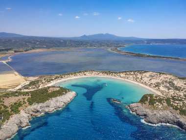Voidokilia 'nın ünlü yarı dairesel kumlu plajı ve lagününün hava manzarası. Yunanistan 'ın Messenia kentinde kristal berrak turkuaz suyu bulunan Akdeniz' deki en ikonik plajlardan biridir.