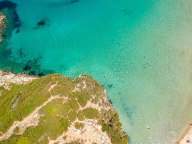 Voidokilia 'nın ünlü yarı dairesel kumlu plajı ve lagününün hava manzarası. Yunanistan 'ın Messenia kentinde kristal berrak turkuaz suyu bulunan Akdeniz' deki en ikonik plajlardan biridir.