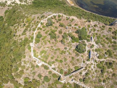 Voidokilia 'nın ünlü yarı dairesel kumlu plajı ve lagününün hava manzarası. Yunanistan 'ın Messenia kentinde kristal berrak turkuaz suyu bulunan Akdeniz' deki en ikonik plajlardan biridir.