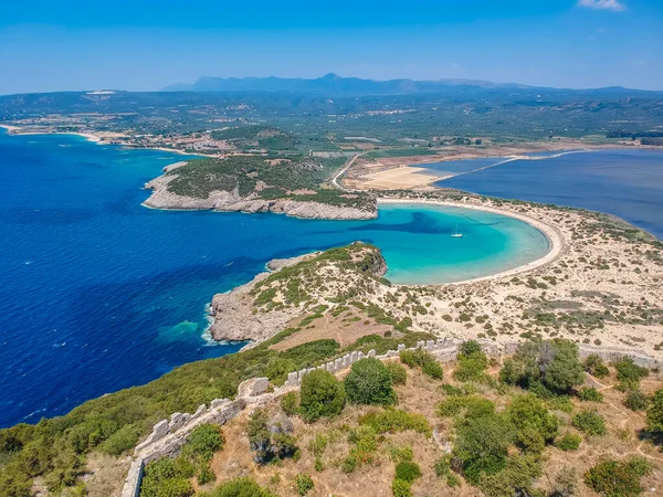 Voidokilia 'nın ünlü yarı dairesel kumlu plajı ve lagününün hava manzarası. Yunanistan 'ın Messenia kentinde kristal berrak turkuaz suyu bulunan Akdeniz' deki en ikonik plajlardan biridir.