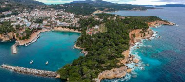 Votsi plajı (Paralia Votsi) ve Sporades, Yunanistan ve Avrupa 'da kış döneminde Alonnisos adasında geleneksel ahşap balıkçı tekneleri bulunan pitoresk liman üzerindeki hava manzarası.