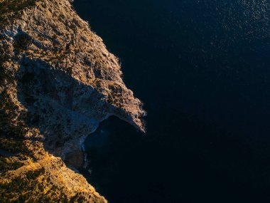 Günbatımında Alonnisos adasının batısındaki insansız hava aracı görüntüsü. Doğal manzara, güzel kayalık manzara, Sporades 'da muhteşem manzara, Ege denizi, Yunanistan