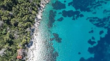 Alonissos Adası, Sporades, Yunanistan 'daki Leftos Gialos kayalık plajı üzerindeki hava manzarası